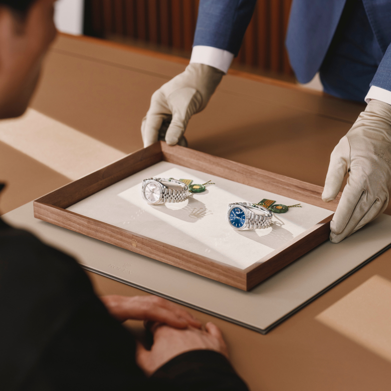 A lady overlooking a Rolex watch being presented to her