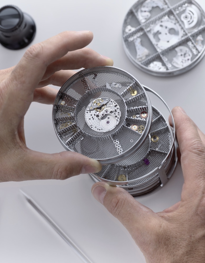Hands holding a basket with all pieces of the Rolex watch